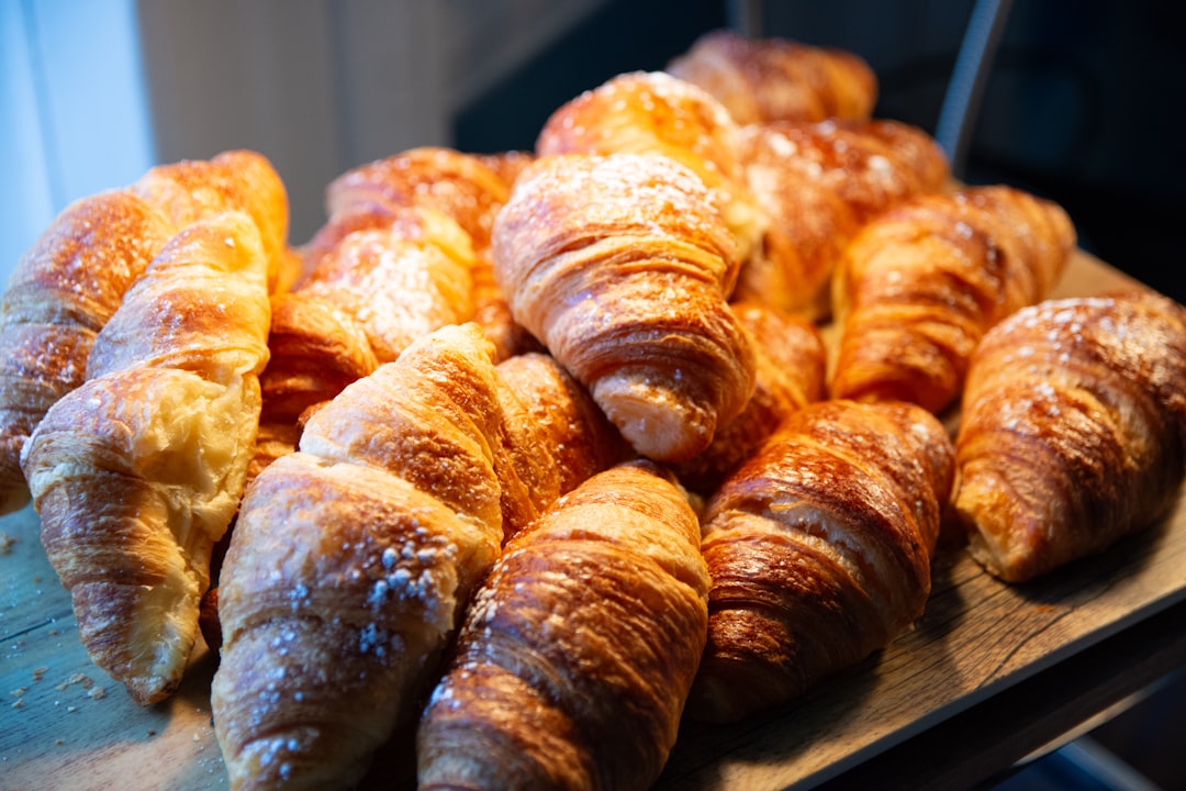 A pile of freshly baked croissants dusted with sugar.