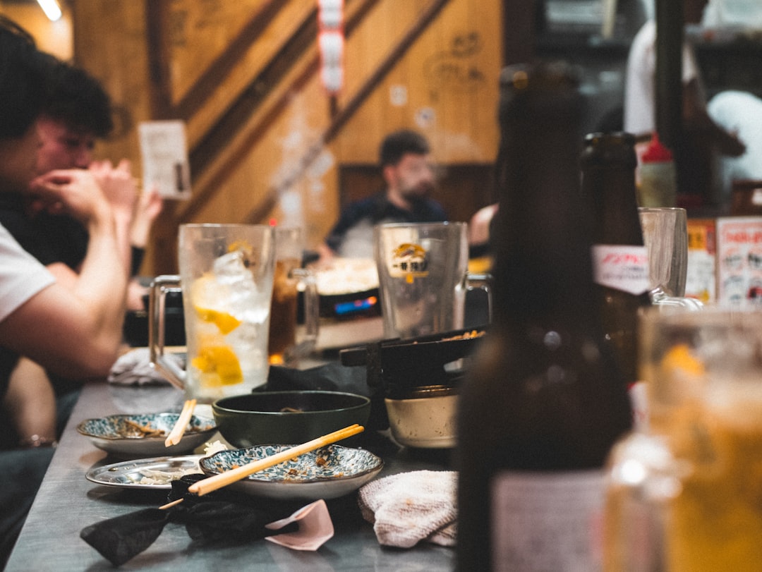 Messy table after a meal with drinks and dishes.