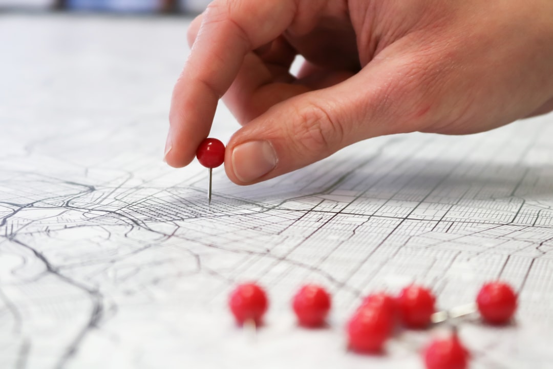 person placing red pin on city map