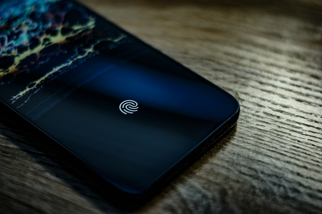 スマートフォンのロック画面で指紋認証をする手元